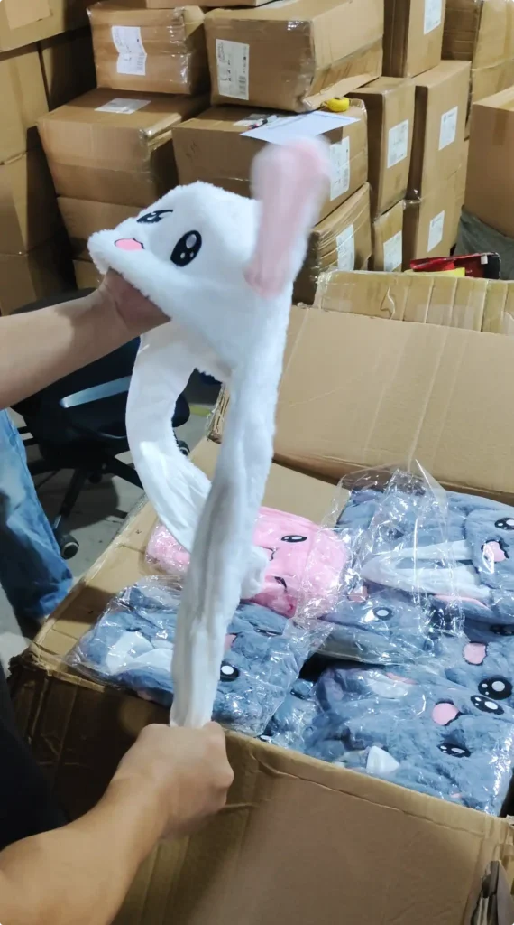 Supplier testing the moving-ear function of a white bunny hat
