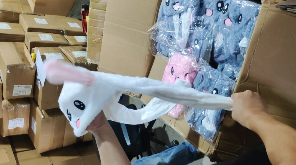 Supplier testing the moving-ear function of a white bunny hat